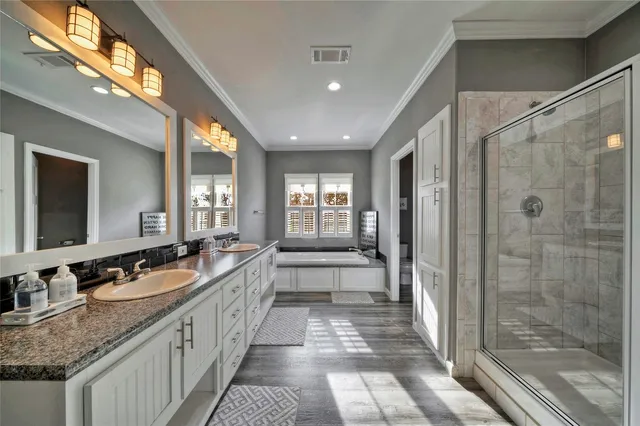 a large bathroom with a granite countertop tub a double vanity sink and a mirror