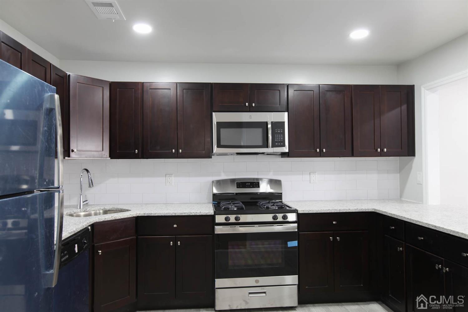 3704 Hana Road Edison, NJ 08817 - Photo 4 of 15 a kitchen with granite countertop stainless steel appliances and wooden cabinets