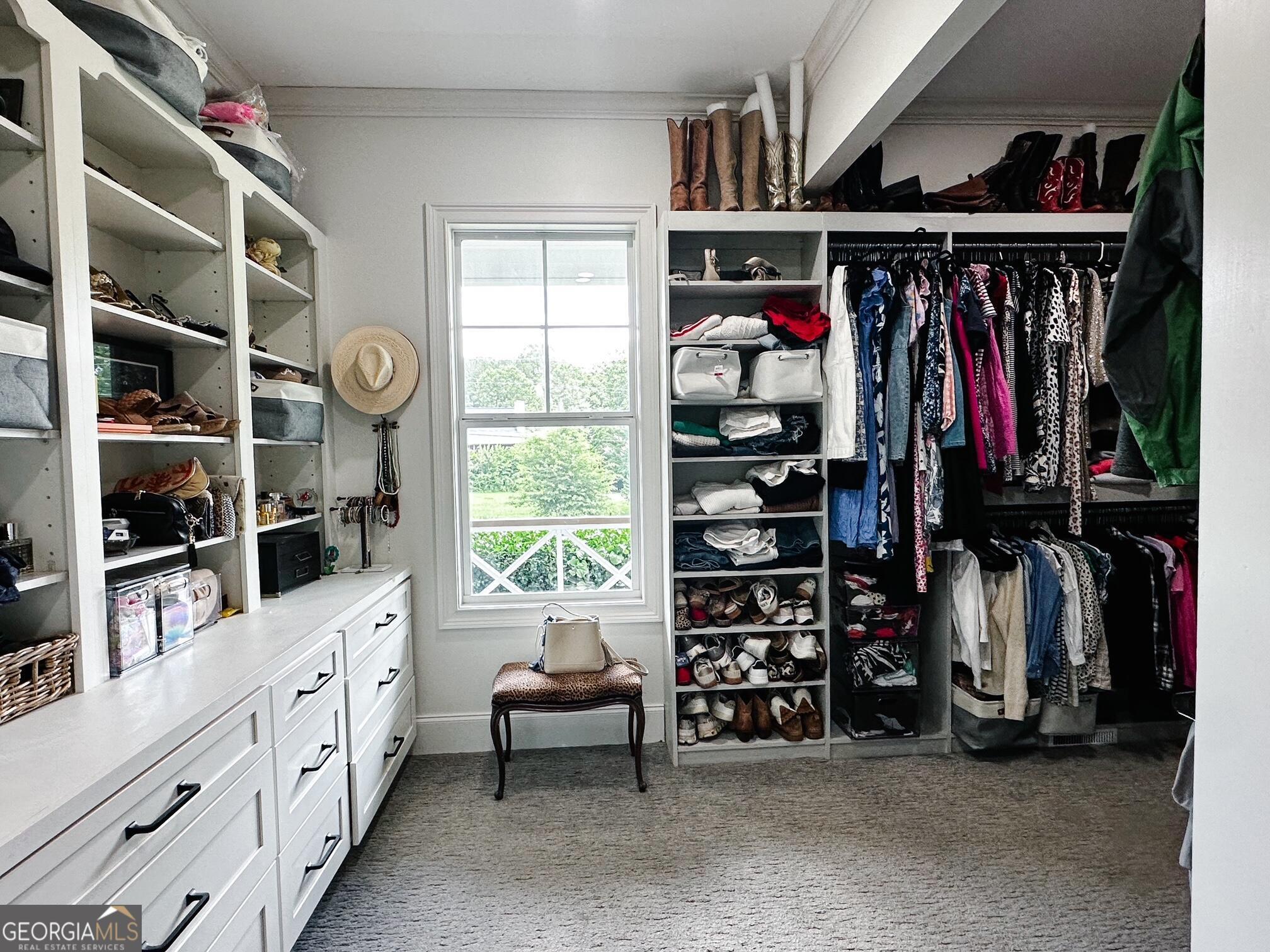 7093 Vaughn Road Woodstock, GA 30188 - Photo 14 of 41 a view of walk in closet with clothes and shoes