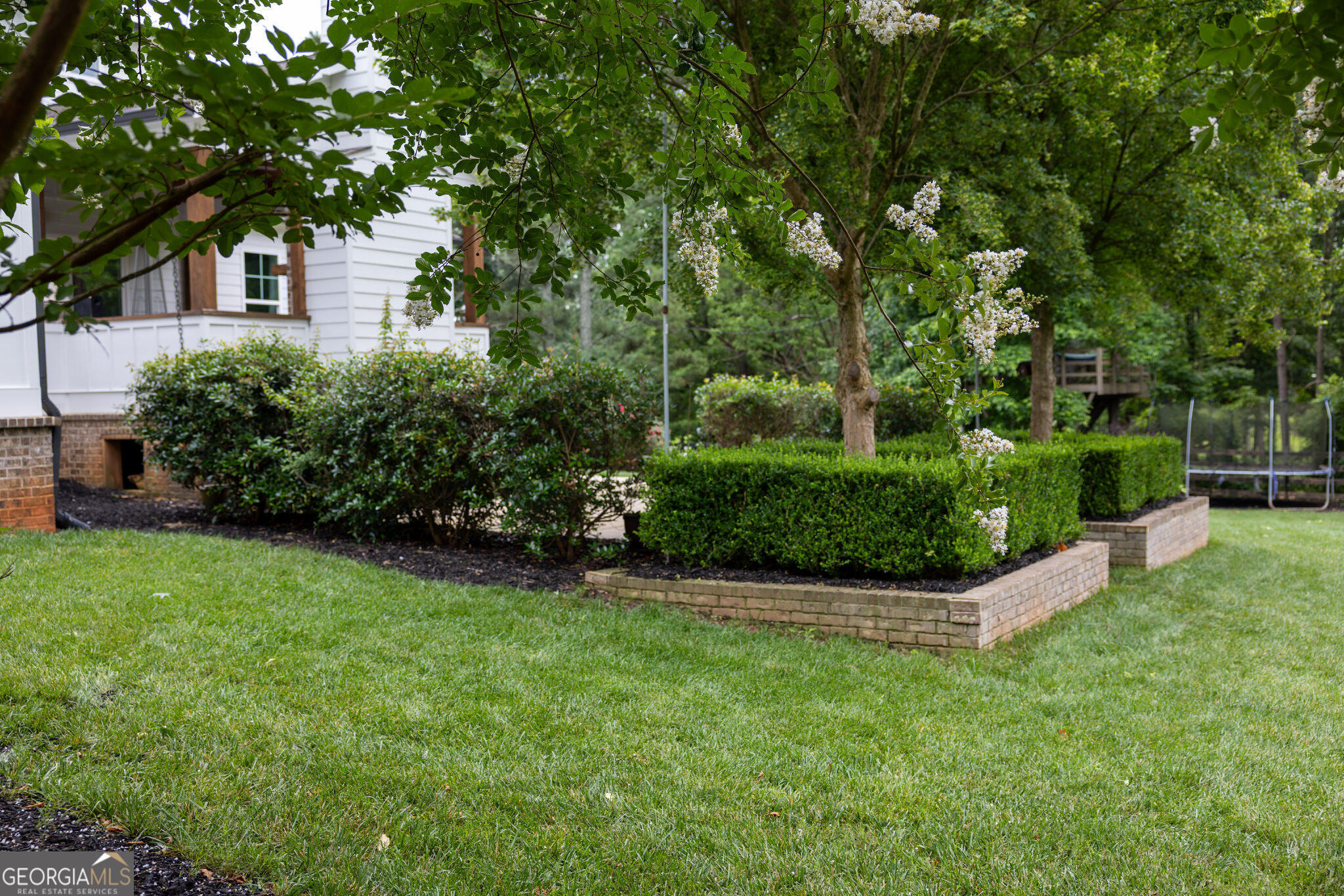 7093 Vaughn Road Woodstock, GA 30188 - Photo 38 of 41 a view of a garden with a house in the background