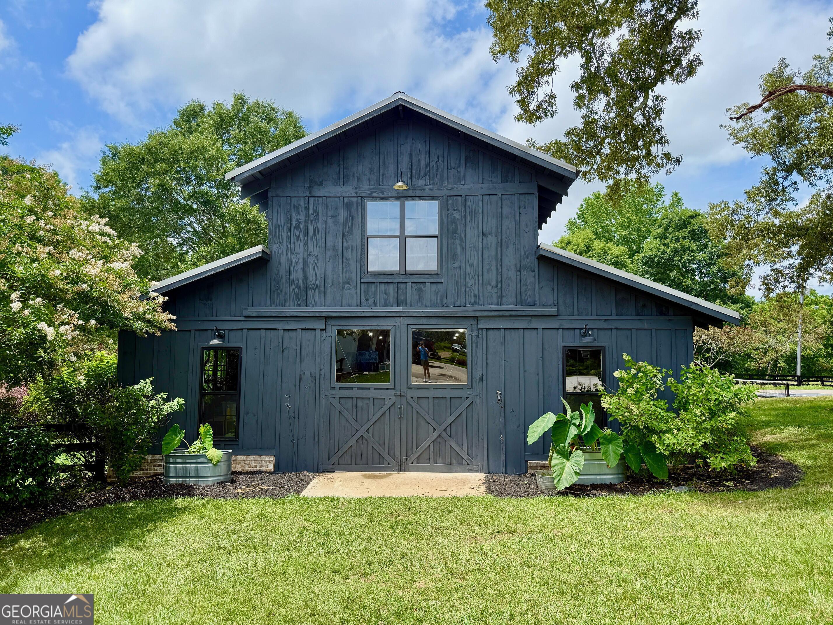 7093 Vaughn Road Woodstock, GA 30188 - Photo 5 of 41 a brick house with potted plants yard and a large tree