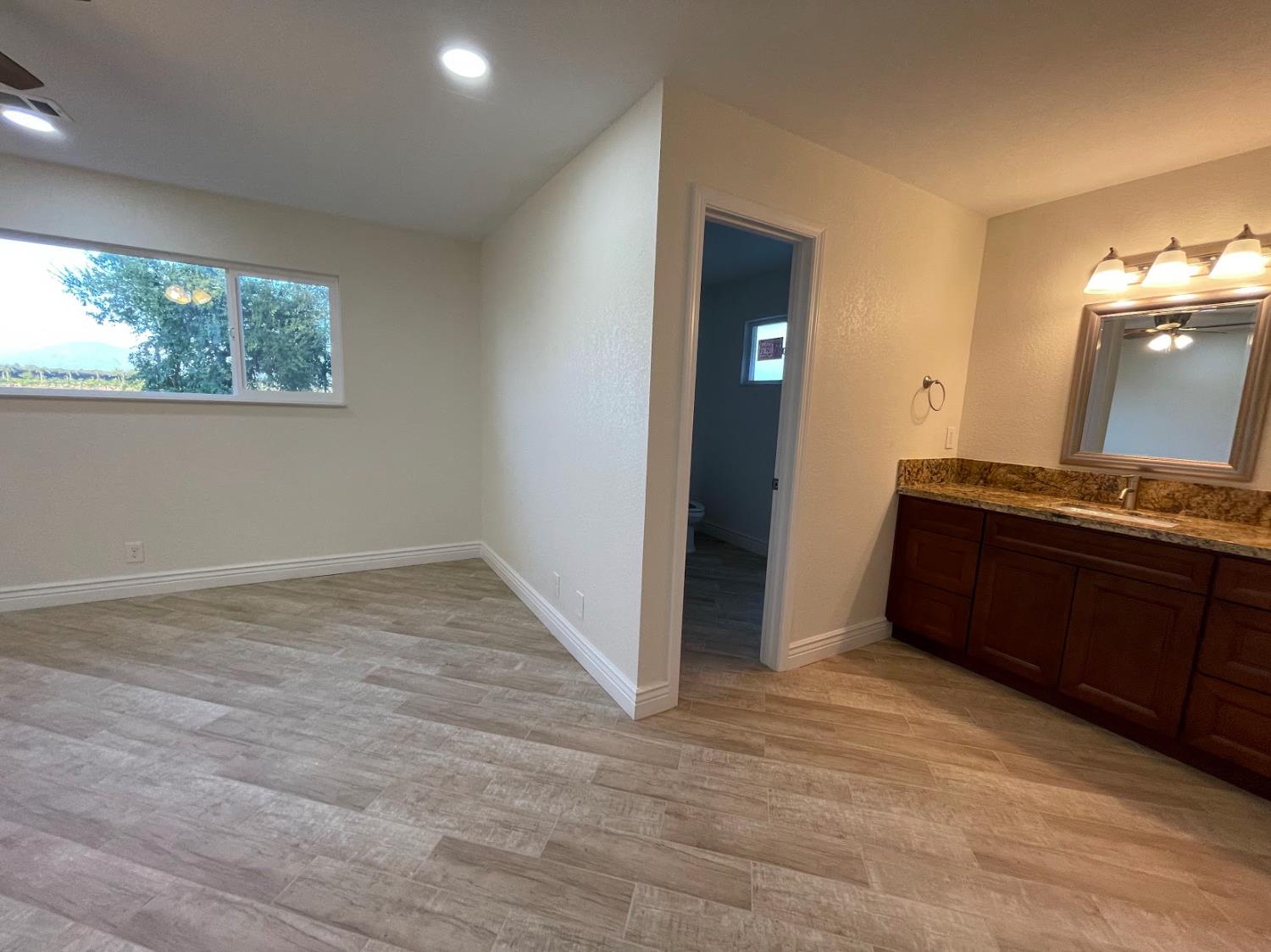 19342 East South Avenue Reedley, CA 93654 - Photo 21 of 29 en empty room with window and bathroom