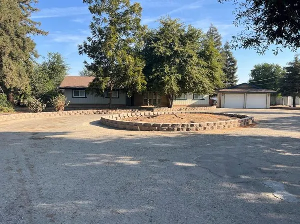 a view of a house with yard and covered with trees