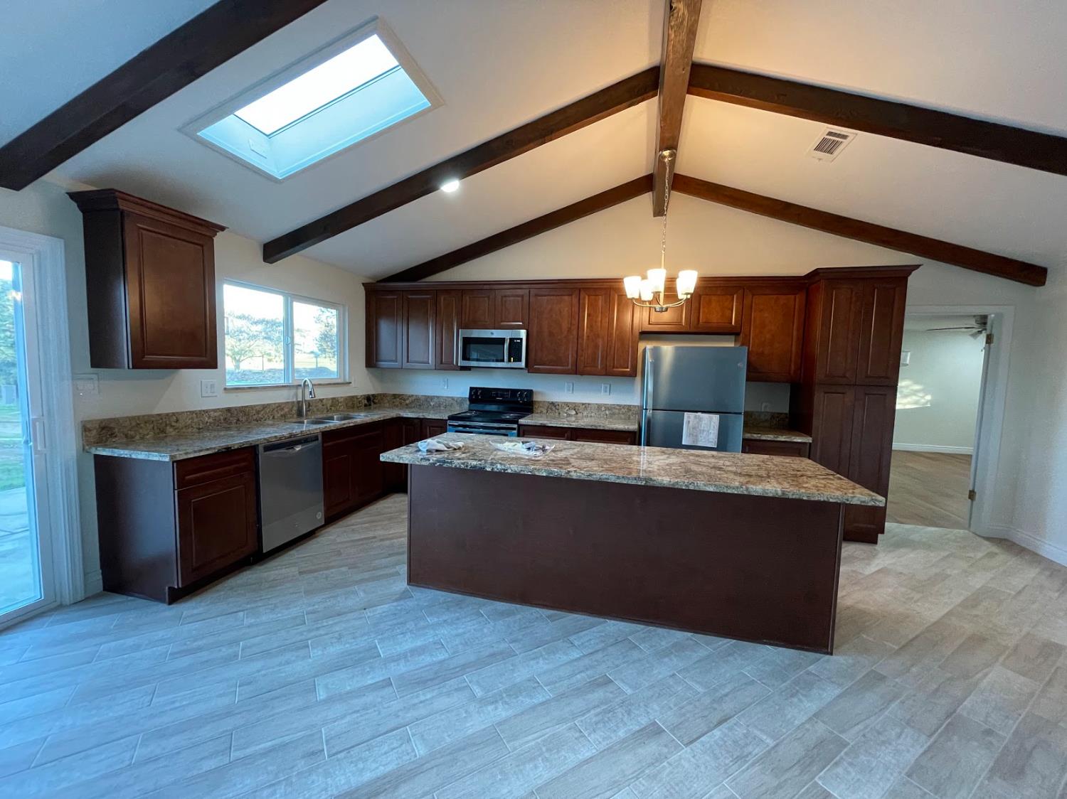 19342 East South Avenue Reedley, CA 93654 - Photo 10 of 29 a large kitchen with stainless steel appliances granite countertop a stove and a wooden cabinets