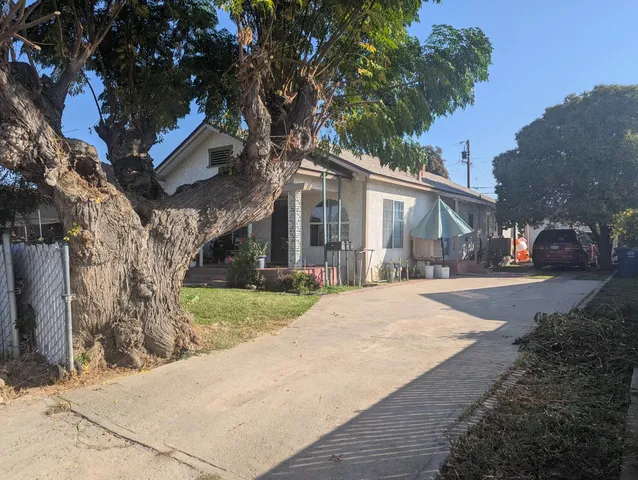 a front view of a house with a yard and potted plants
