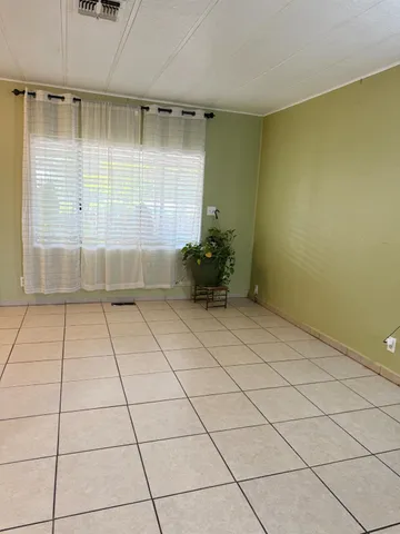 a view of an empty room with a fireplace and a window