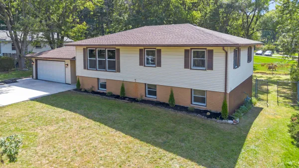 a kitchen with stainless steel appliances granite countertop a stove a sink dishwasher a refrigerator and white cabinets with wooden floor