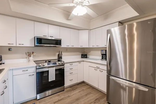 a kitchen with appliances a sink and cabinets