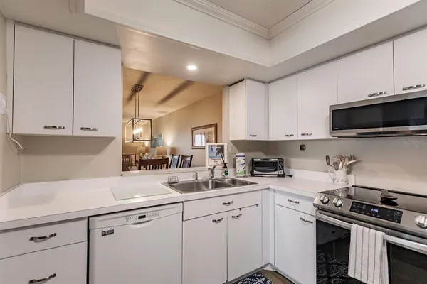 a kitchen with a sink a refrigerator a microwave a stove and cabinets