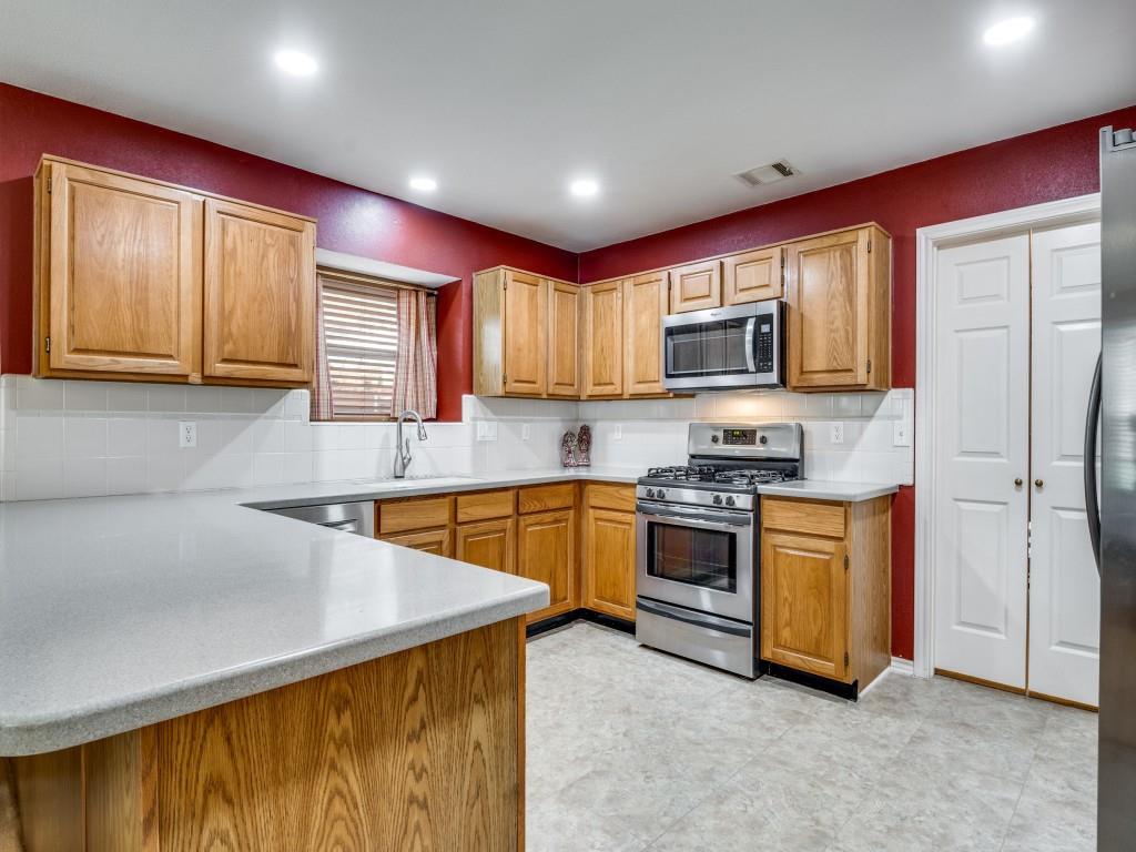 1317 Chestnut Drive Rowlett, TX 75089 - Photo 7 of 25 a kitchen with stainless steel appliances granite countertop a stove top oven a sink dishwasher a refrigerator and a microwave