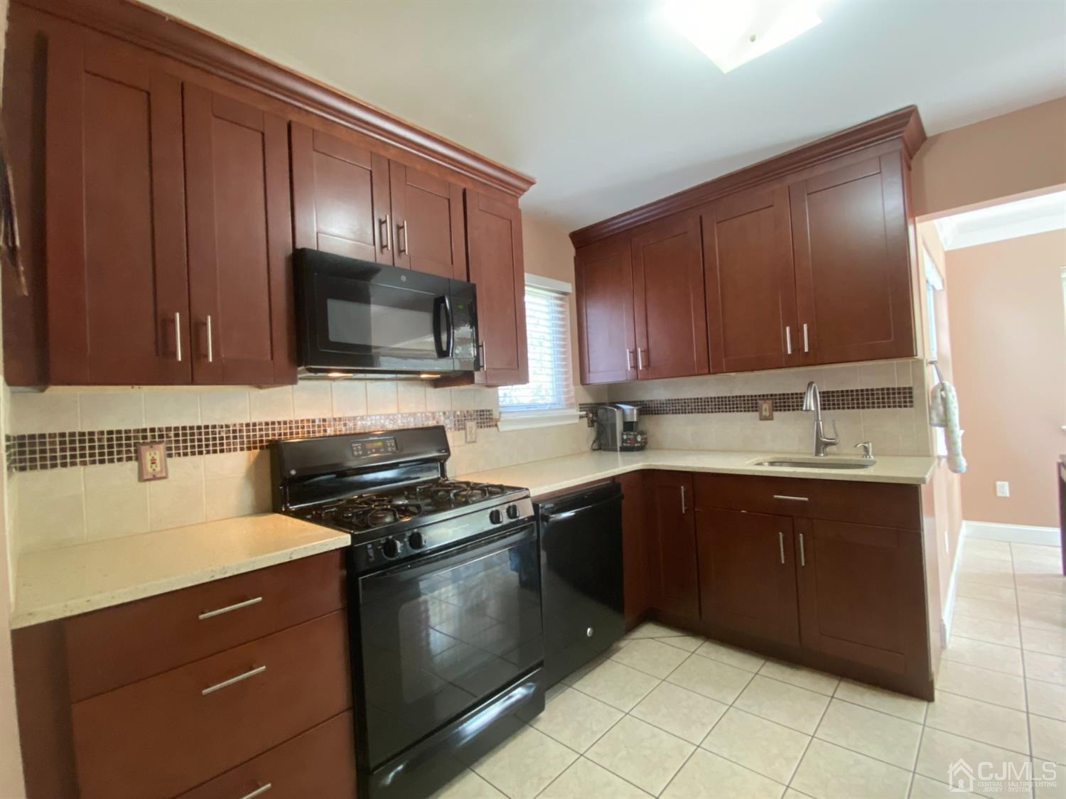 56 Whitehead Road Bridgewater, NJ 08807 - Photo 4 of 42 a kitchen with granite countertop wooden cabinets and stainless steel appliances