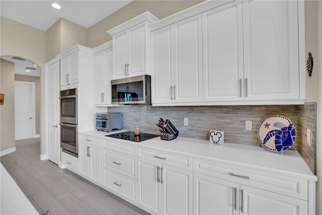 105 Night Hawk Way Sebastian, FL 32958 - Photo 9 of 36 a kitchen with white cabinets and sink