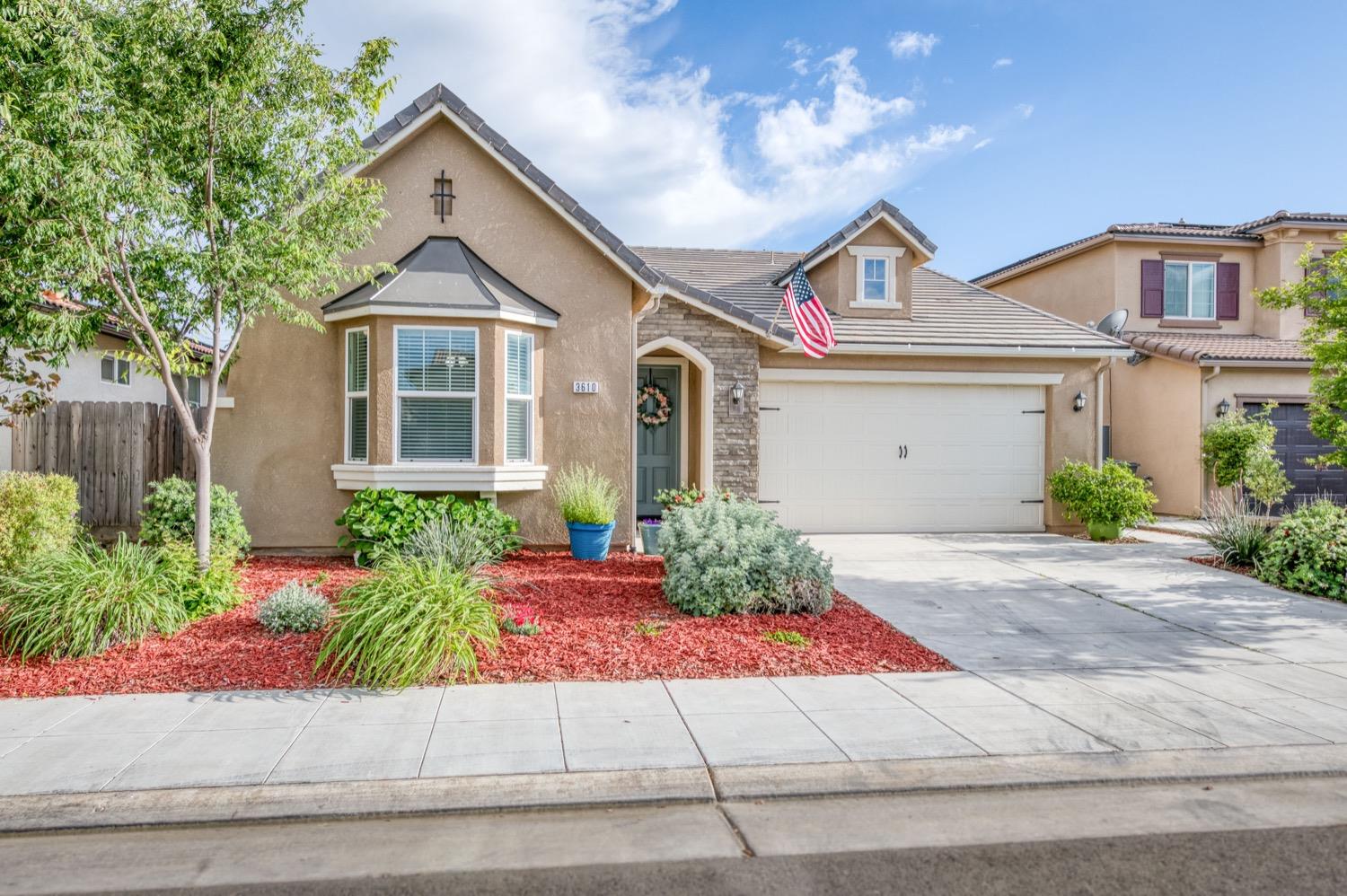 3610 Griffith Avenue Clovis, CA 93619 - Photo 2 of 22 a front view of a house with a yard and a garage