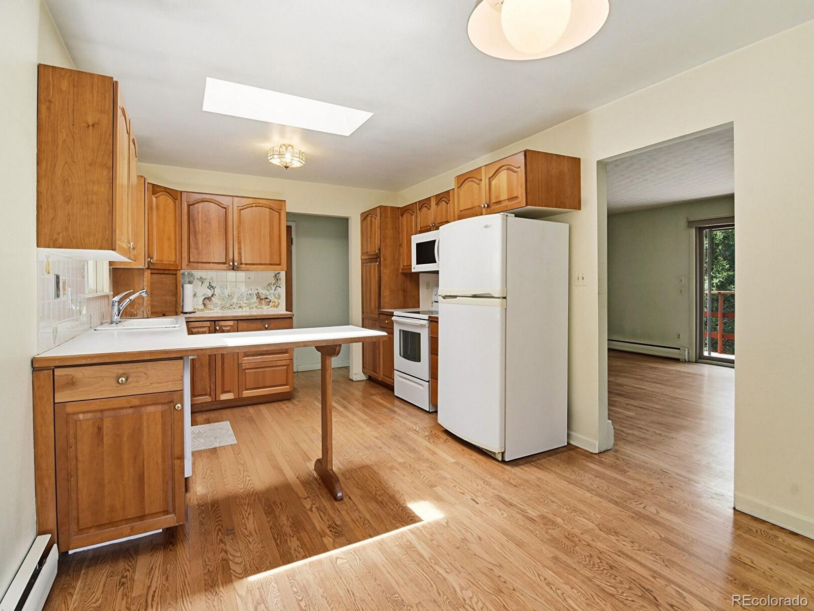 2830 Kerr Gulch Road Evergreen, CO 80439 - Photo 14 of 48 a kitchen with a refrigerator a sink and cabinets