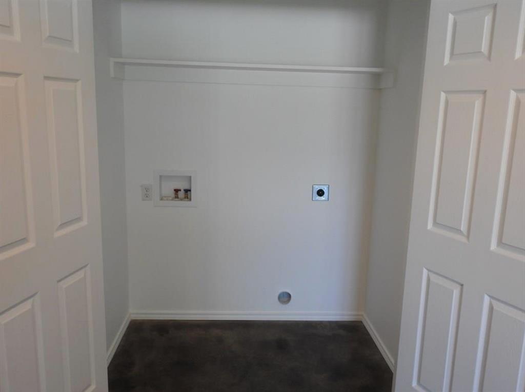 704 Seven Oaks Road Bonham, TX 75418 - Photo 9 of 11 Dedicated utility closet with a white adjustable shelving unit, white baseboards, and a dark floor