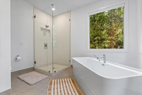 a bathroom with a sink a toilet a glass door shower and a mirror