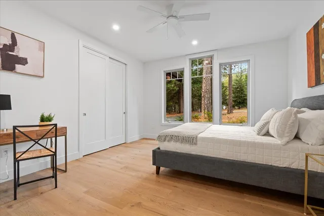 a bedroom with a bed a chair and potted plant with the outer view