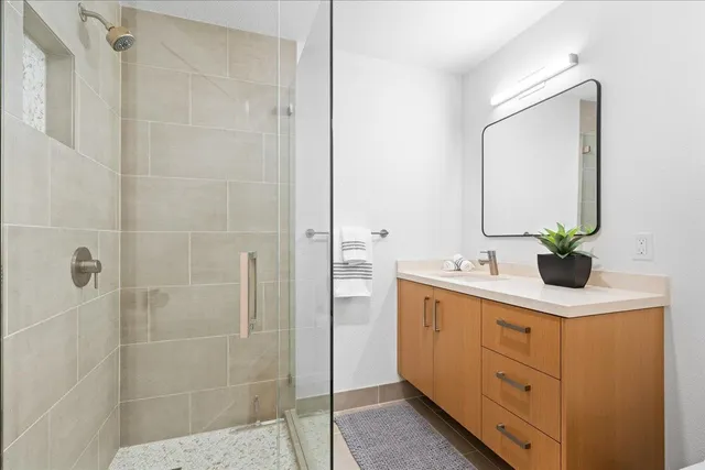 a bathroom with a sink a mirror and a shower