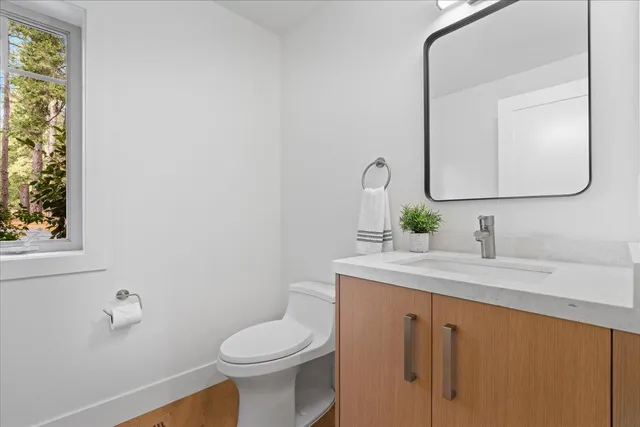 a bathroom with a toilet sink and mirror