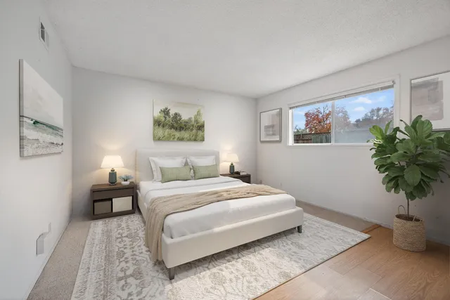 a bedroom with a large bed and a potted plant