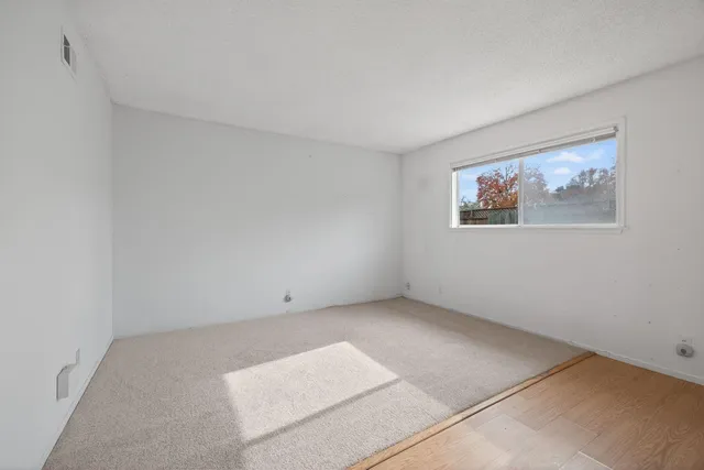 an empty room with a painting on the wall