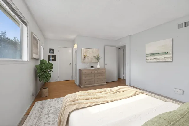 a bedroom with a large bed a chandelier and closet