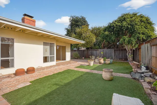 a view of a house with backyard and sitting area