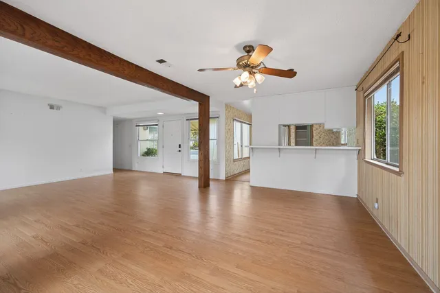 a view of a kitchen with wooden floor and a kitchen space with a sink