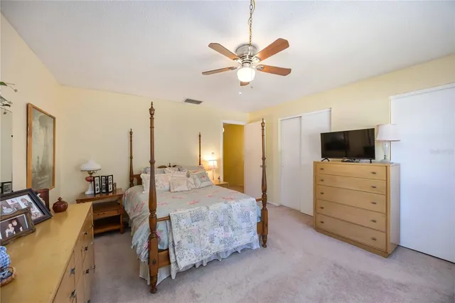a bedroom with a bed a flat tv screen and dresser