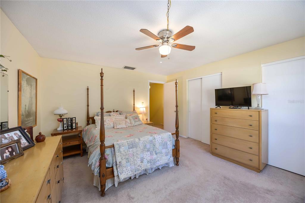 4885 Rilma Avenue, Unit 131 Sarasota, FL 34234 - Photo 12 of 25 a bedroom with a bed a flat tv screen and dresser