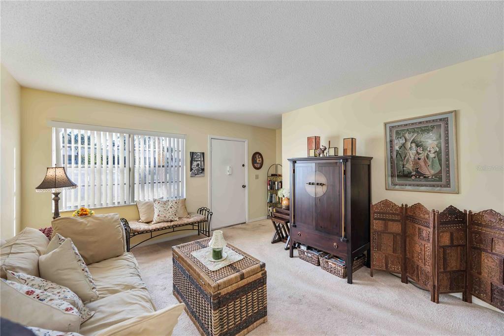 4885 Rilma Avenue, Unit 131 Sarasota, FL 34234 - Photo 3 of 25 a living room with furniture a window and a flat screen tv