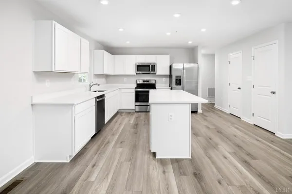 a large kitchen with a sink and a stove top oven