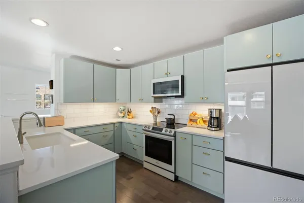 a kitchen with a sink white cabinets and stainless steel appliances