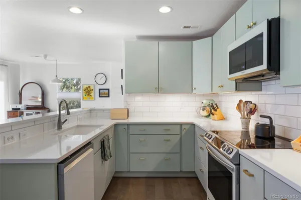 a kitchen with a sink a stove and cabinets