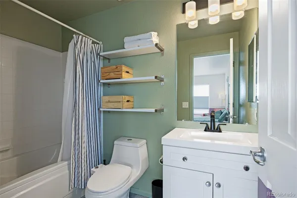 a bathroom with a sink a toilet and shower curtain