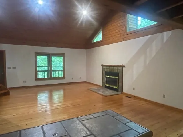 an empty room with a fireplace and windows
