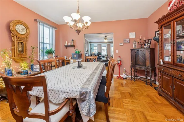 a view of a dining room with furniture a chandelier and large window