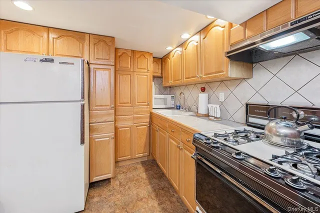 a kitchen with stainless steel appliances granite countertop a refrigerator and a stove