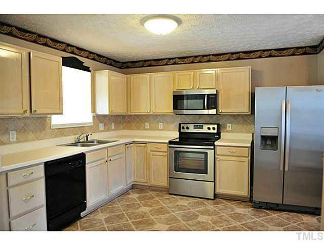 3715 Ranbir Drive Durham, NC 27713 - Photo 5 of 23 Tile flooring, stainless steel fridge and smooth top cooktop Kitchen
