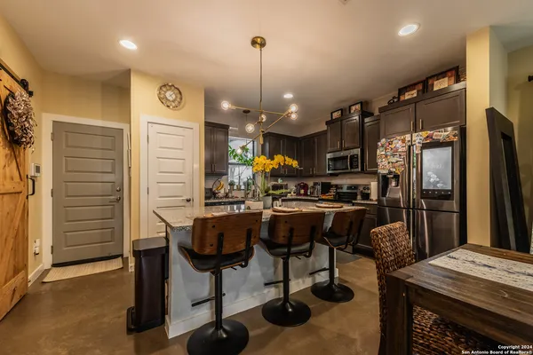 a kitchen with granite countertop a table chairs stove and wooden floor