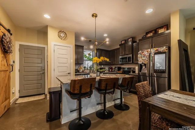 a kitchen with granite countertop a table chairs stove and wooden floor