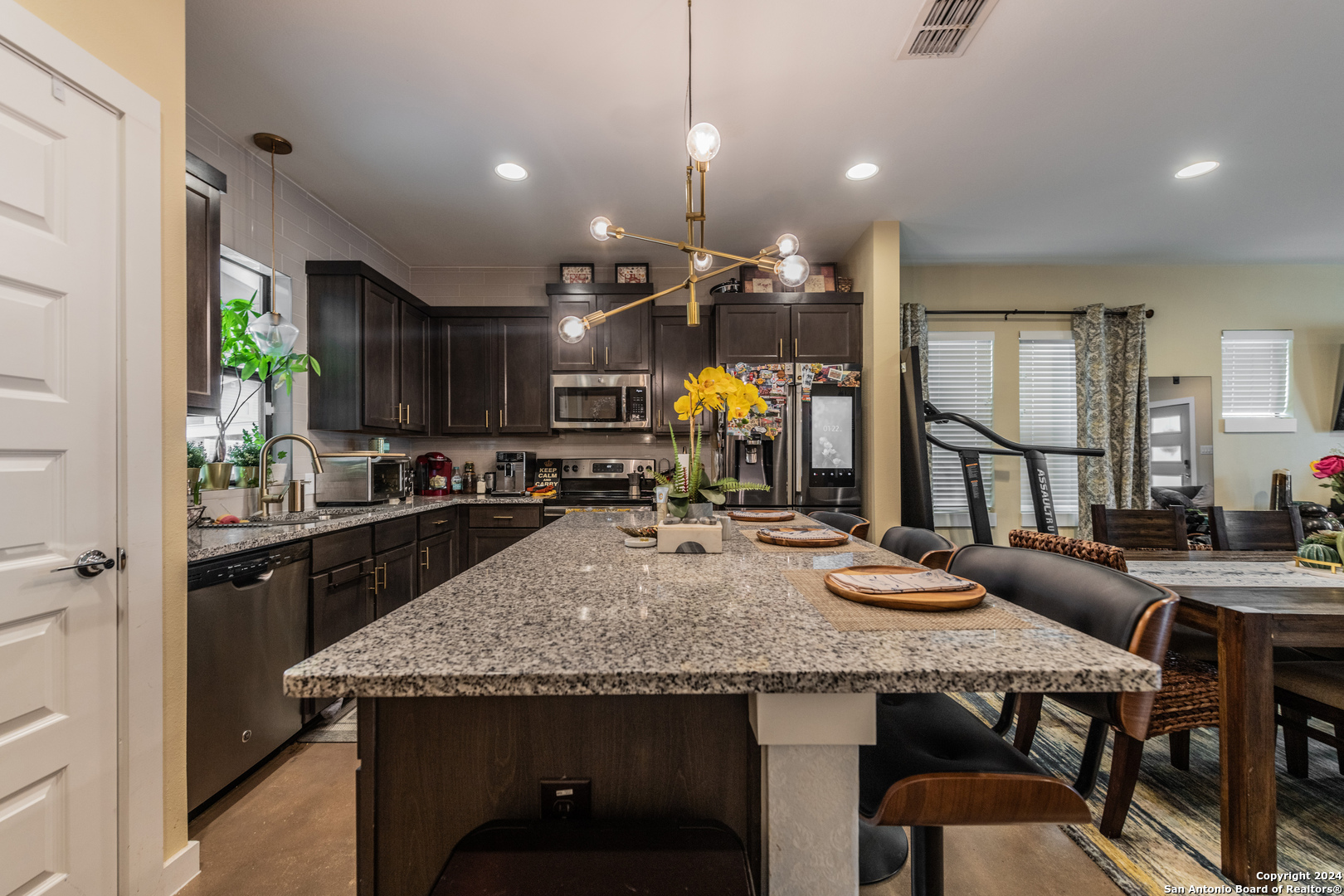 619 Burleson San Antonio, TX 78202 - Photo 9 of 21 a kitchen with granite countertop a table chairs stove and wooden floor