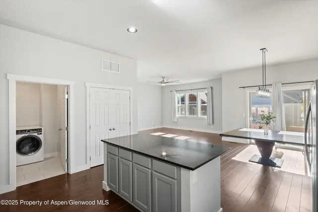 a kitchen with stainless steel appliances kitchen island granite countertop a sink cabinets and wooden floor