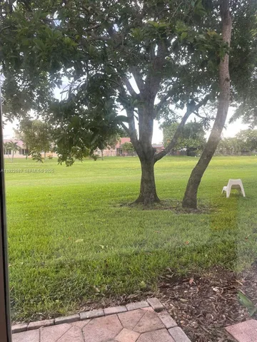 a view of a livingroom with a large window a chandelier fan and windows