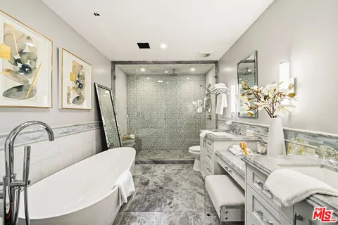 a picture of a bathroom with mirror and vanity