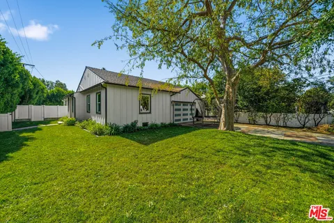 a view of a house with backyard and a tree