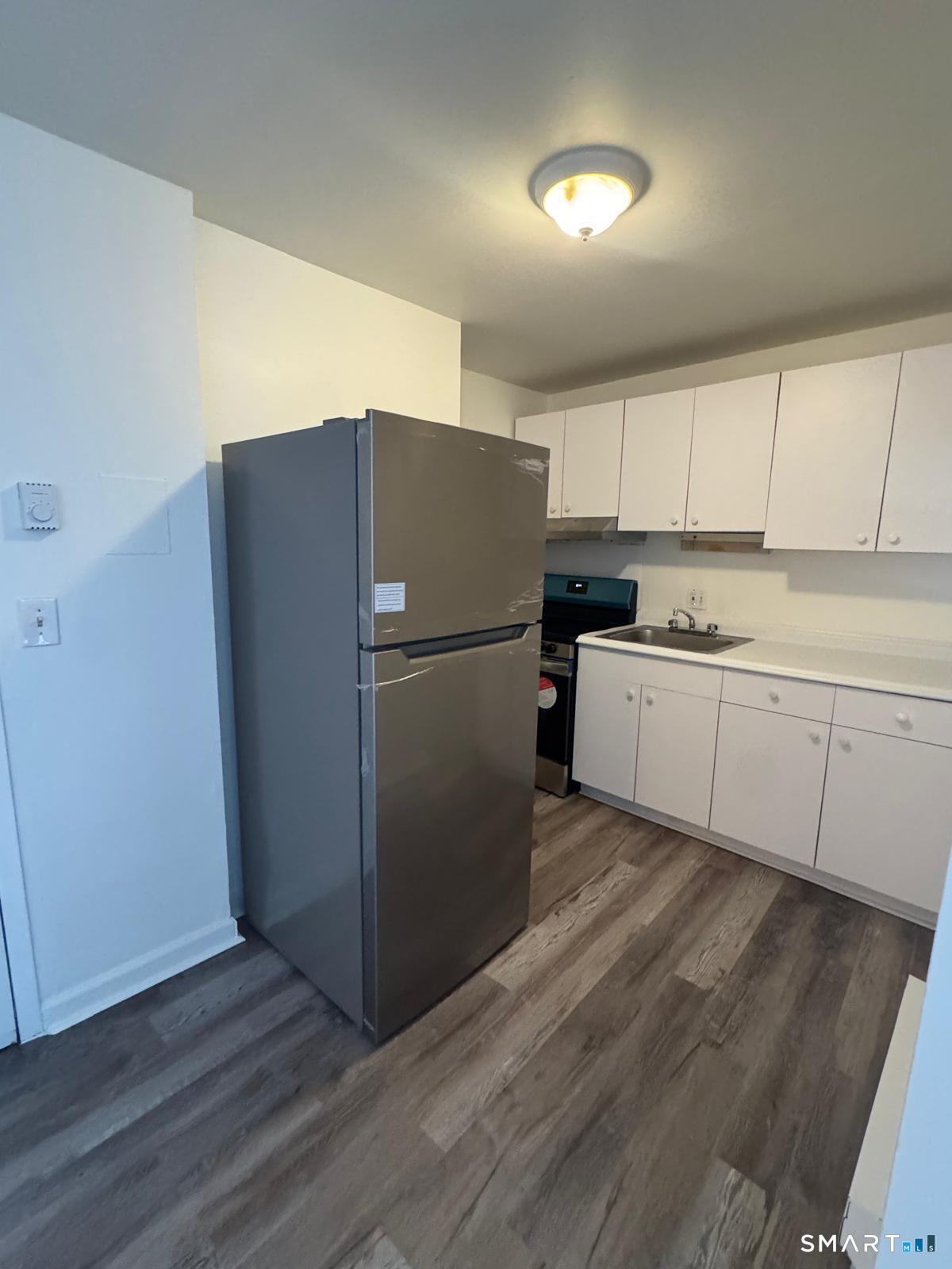 a kitchen with a refrigerator sink and cabinets