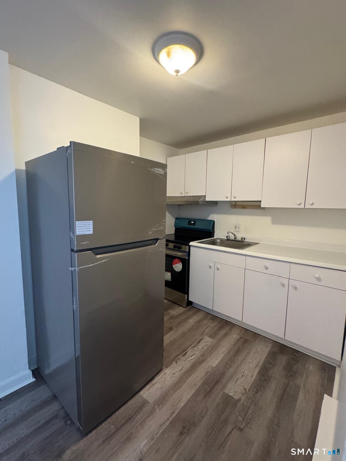 832 Atlantic Street, Unit 2A Bridgeport, CT 06604 - Photo 2 of 11 a kitchen with cabinets and stainless steel appliances