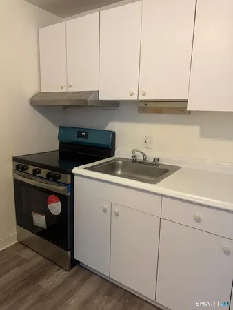 a kitchen with granite countertop white cabinets and a stove