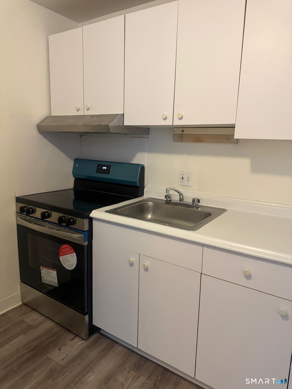 832 Atlantic Street, Unit 2A Bridgeport, CT 06604 - Photo 3 of 11 a kitchen with granite countertop white cabinets and a stove